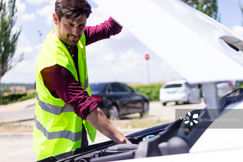 路边救援人员修理抛锚的汽车发动机图片素材