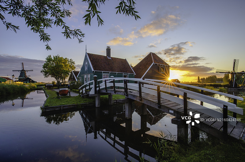 荷兰赞瑟斯汉斯村日出时的木制传统房屋和荷兰风车图片素材