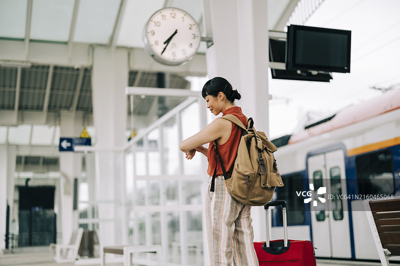 亚洲女人在火车站边走边看时间图片素材