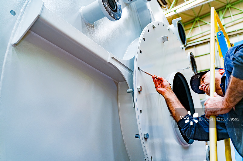 油漆匠将钢材表面涂成白色图片素材