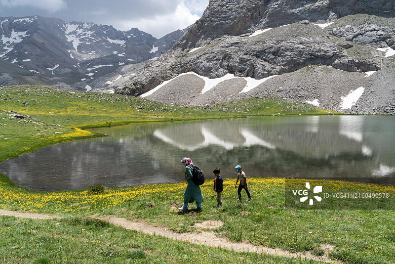 母亲和儿子在尼代博尔卡尔山顶的卡拉格öl冰川湖徒步旅行图片素材