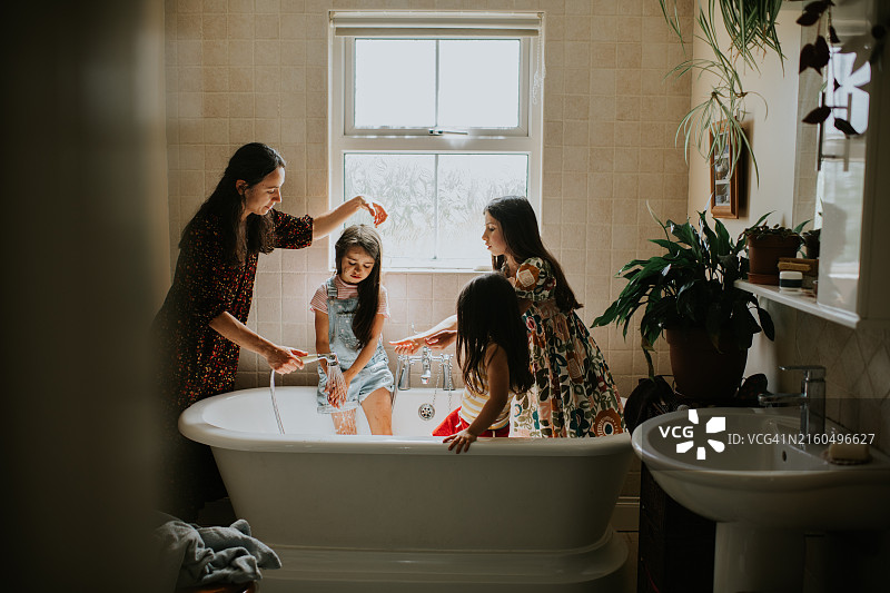 母亲给三个女儿快速淋浴图片素材