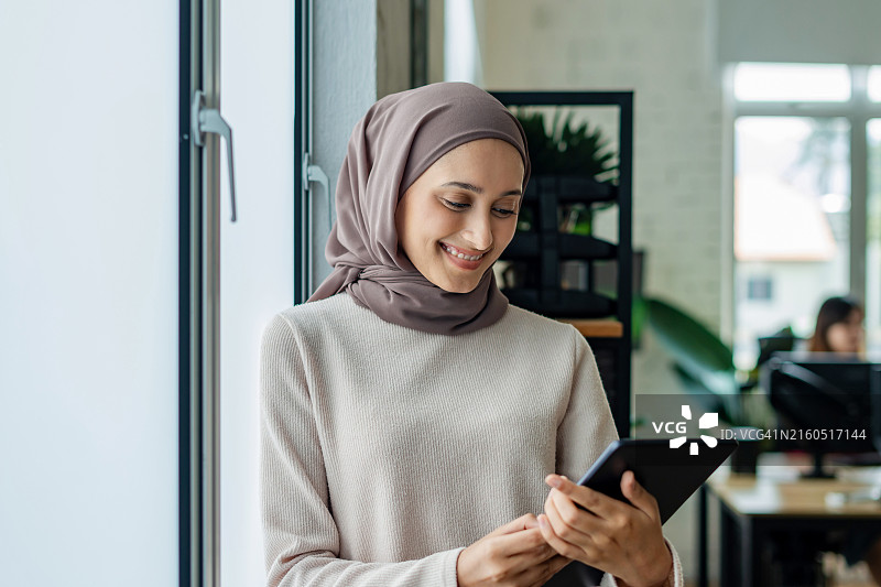 正在使用平板电脑工作的穆斯林女商人图片素材