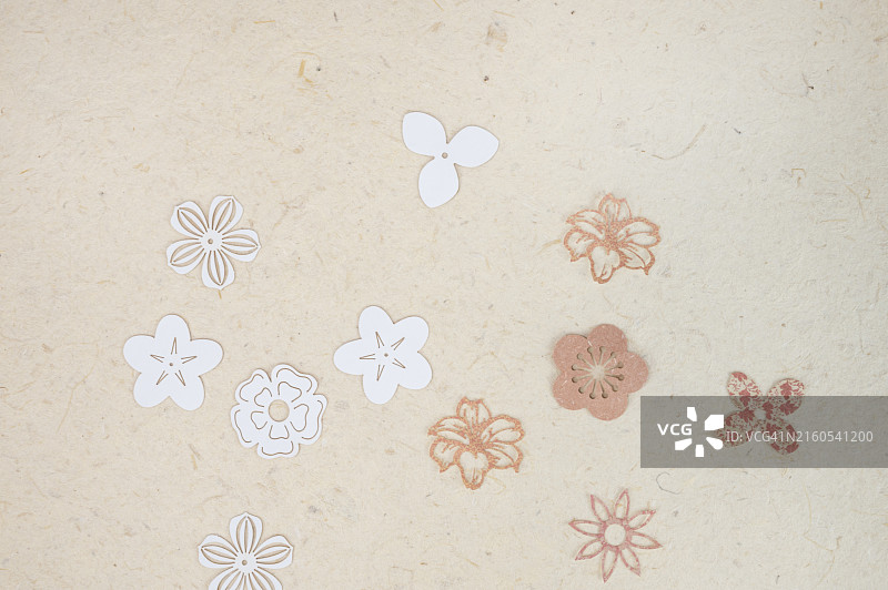 纹理桑蚕纸背景上的花朵剪纸图片素材