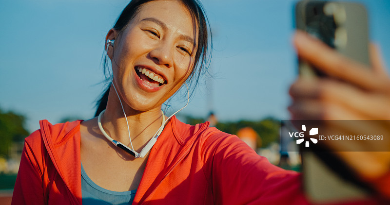 亚洲女运动员与健身教练进行视频通话图片素材