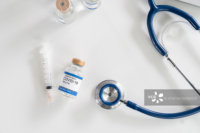 放在白色桌子上的听诊器和疫苗瓶图片素材