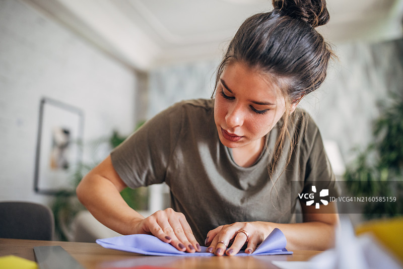 女人在桌子上折纸飞机图片素材
