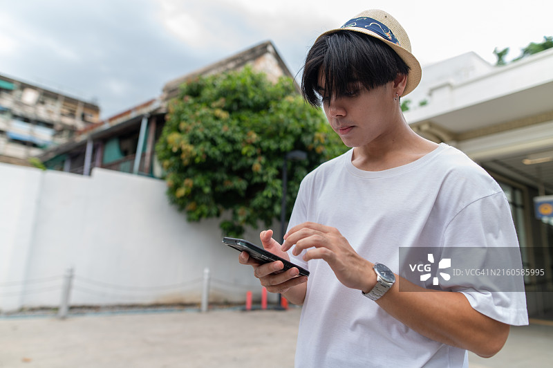 少年使用电子设备等待朋友图片素材