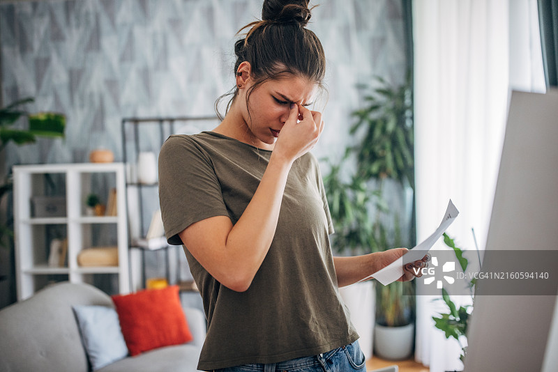 在客厅镜子旁拿着文件的女人图片素材
