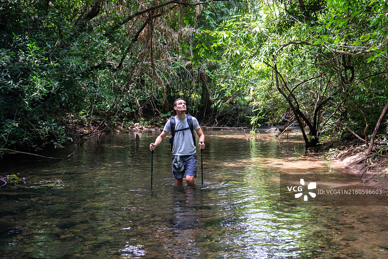 男人在森林溪流中跋涉图片素材
