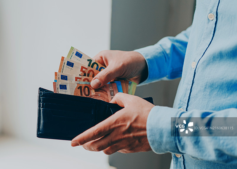 男人从钱包里取出欧元图片素材