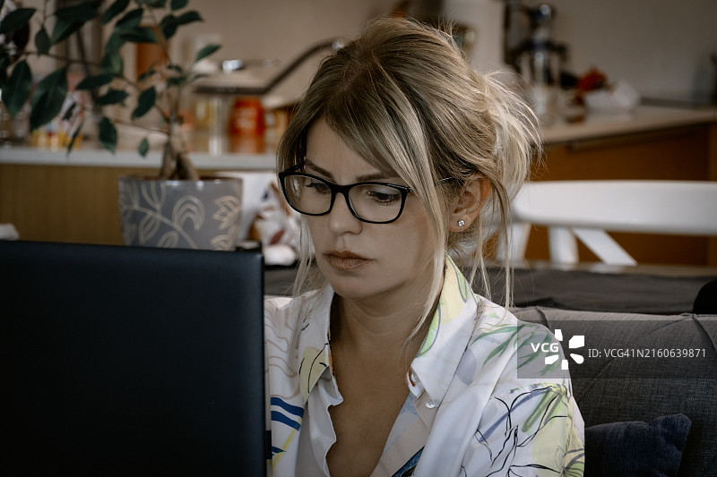 在家用笔记本电脑工作的年轻白人女性图片素材