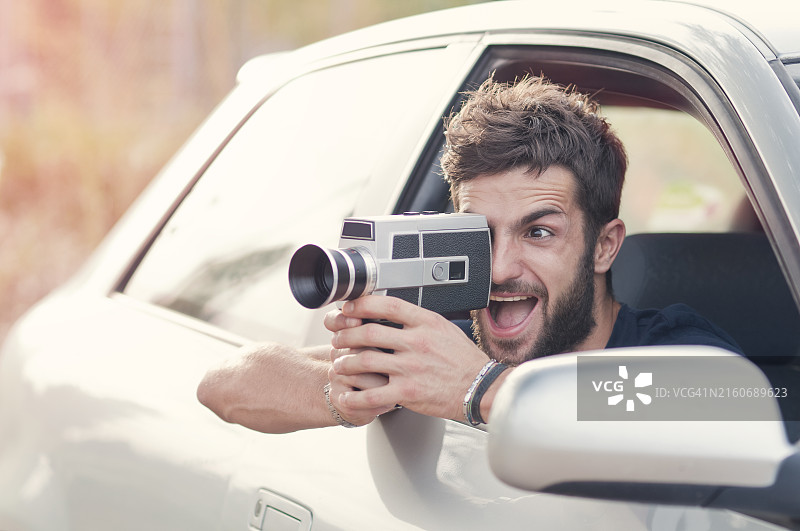 男人使用复古8毫米电影摄影机拍摄图片素材