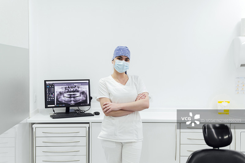 牙医戴着口罩站在诊所里图片素材