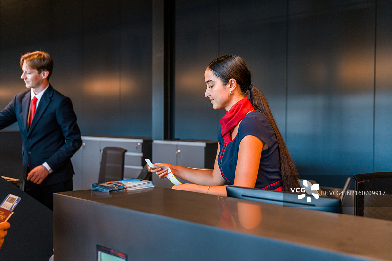 亚洲航空公司年轻空姐正在检查登机牌图片素材