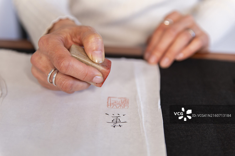 女人在纸上盖日本印章图片素材