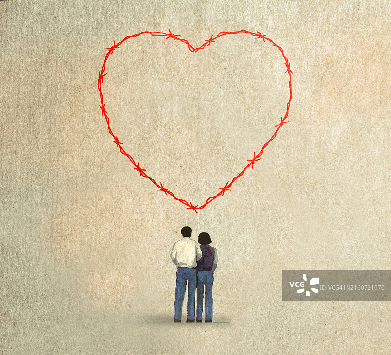 情侣观看带刺铁丝网组成的心形图案图片素材