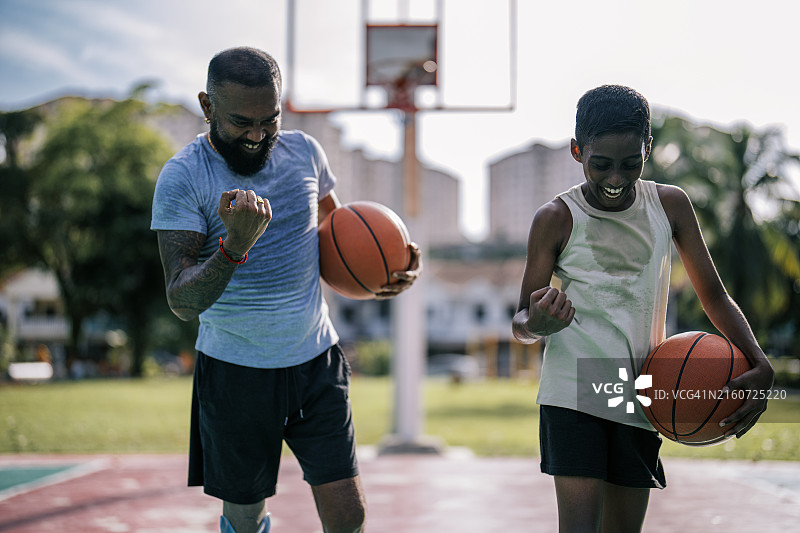 装有假肢的印度父亲和儿子在篮球场享受运动图片素材