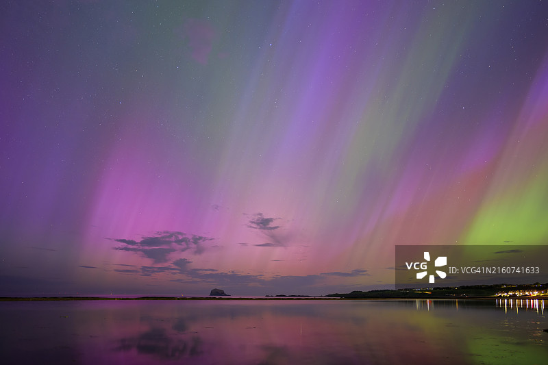 英国苏格兰北贝里克，夜晚沿海城镇上空的北极光图片素材