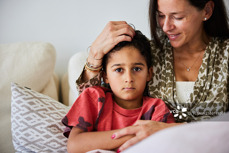 小男孩和妈妈一起坐在客厅的沙发上图片素材