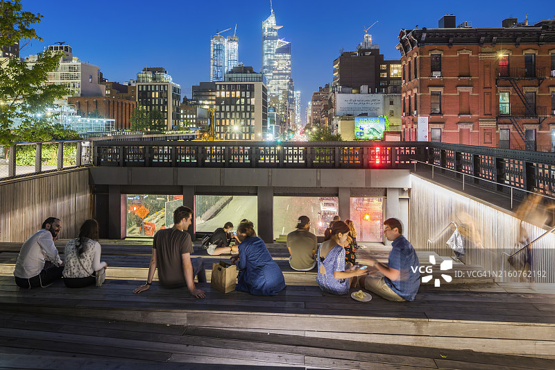 曼哈顿肉类加工区高线公园：人们坐在第10大道广场圆形剧场的台阶上图片素材