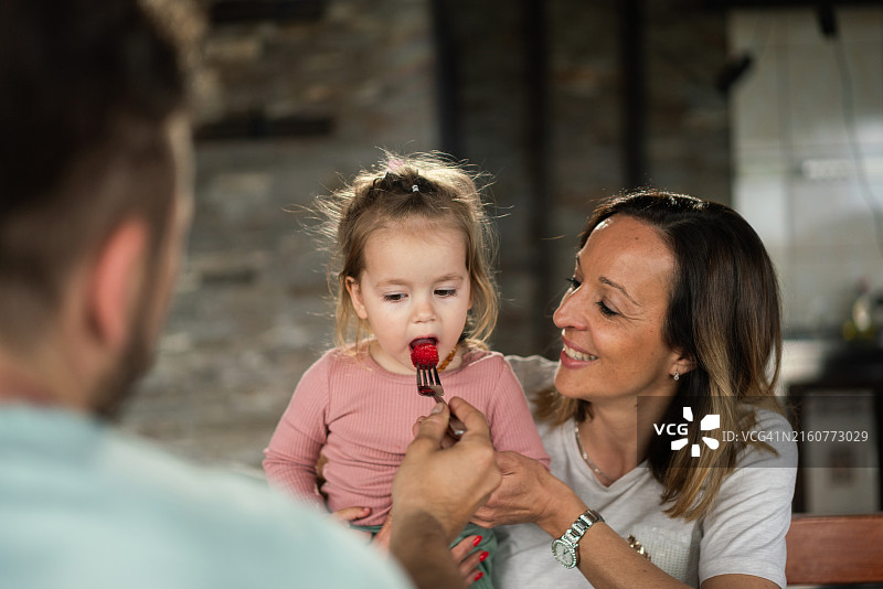 父亲喂女婴吃草莓图片素材