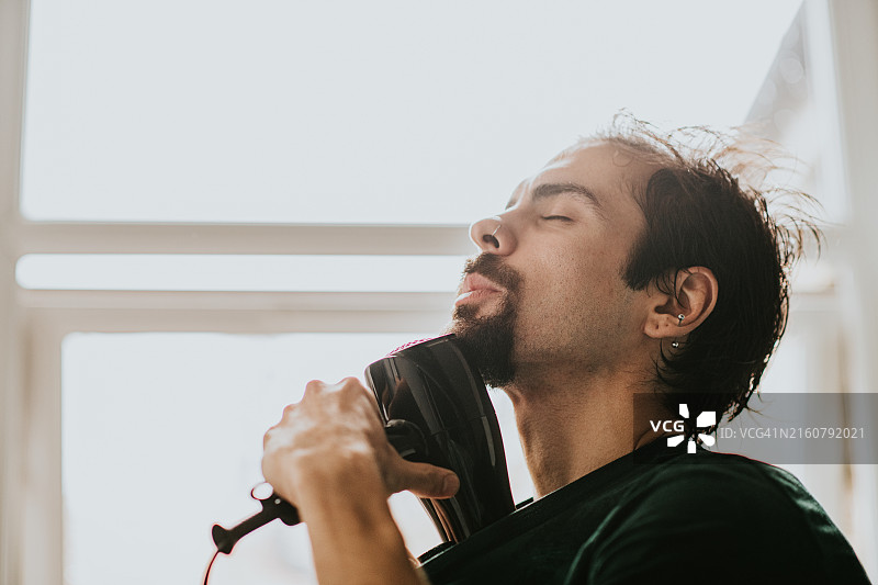 男子用吹风机加热图片素材