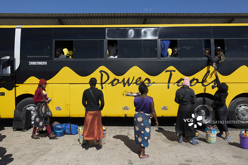 在赞比亚前往利文斯顿的路上，妇女们向巴士乘客出售商品图片素材