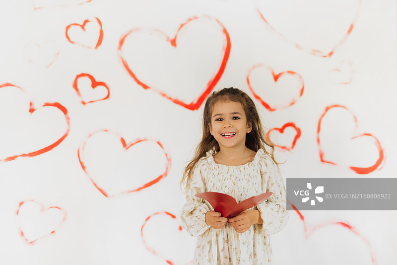 小女孩手中的红色爱心图片素材