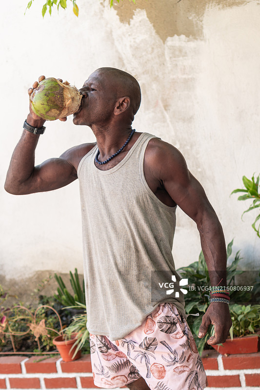 男人在户外饮用新鲜椰子汁图片素材