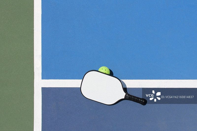 户外：靠在球上的匹克球拍图片素材