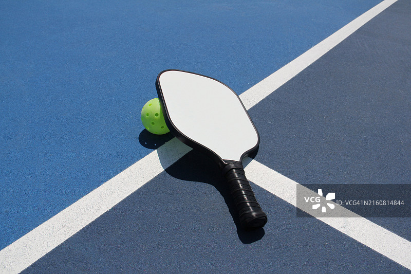 户外石墨匹克球拍靠在球上图片素材