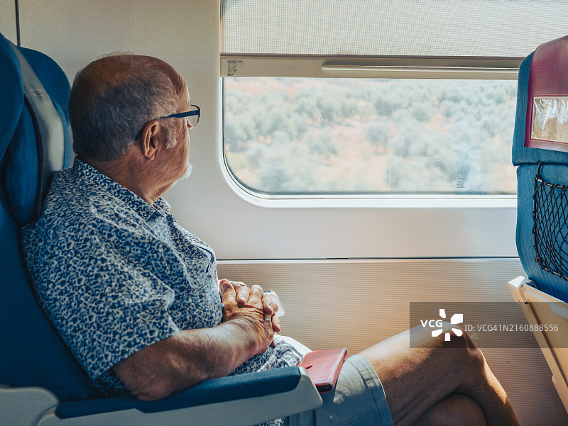 老年男人在火车上欣赏西班牙乡村风光图片素材