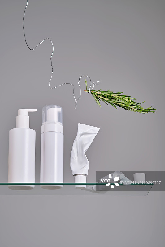 浴室玻璃架子上带有迷迭香的各种面部和身体护理产品图片素材