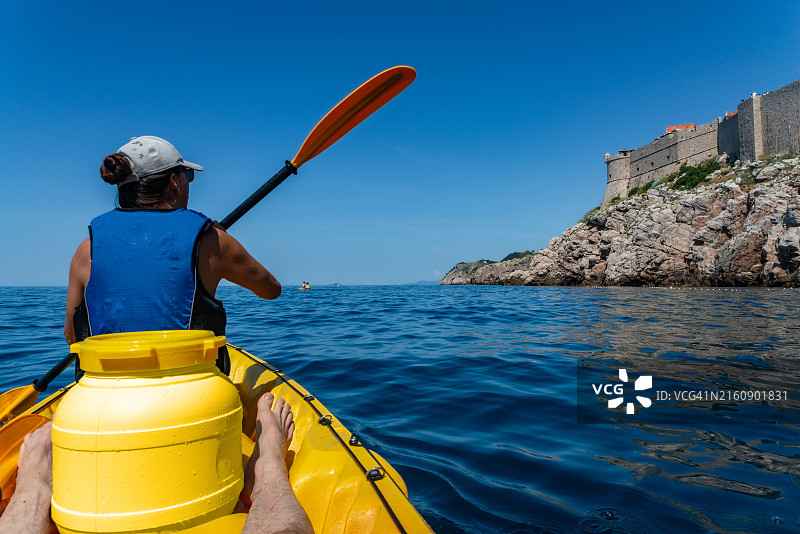 男子在克罗地亚杜布罗夫尼克海中划皮划艇的背影图片素材