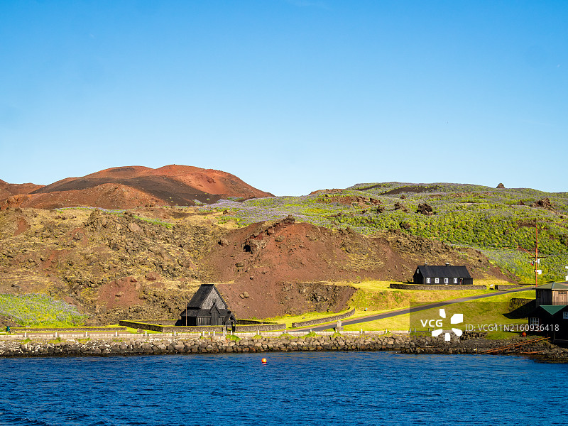 海马岛港口的码头，可欣赏木板教堂、传统房屋和火山景观，南冰岛图片素材