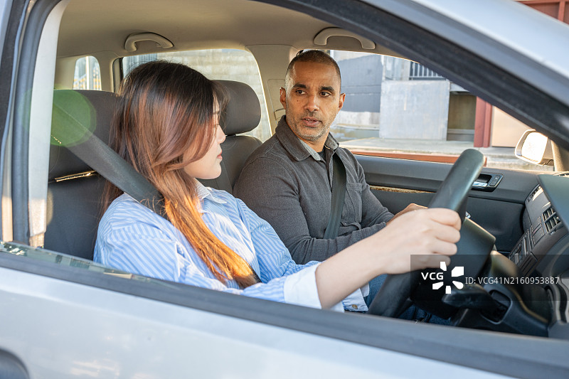 女学员司机听取驾驶检查员的意见图片素材
