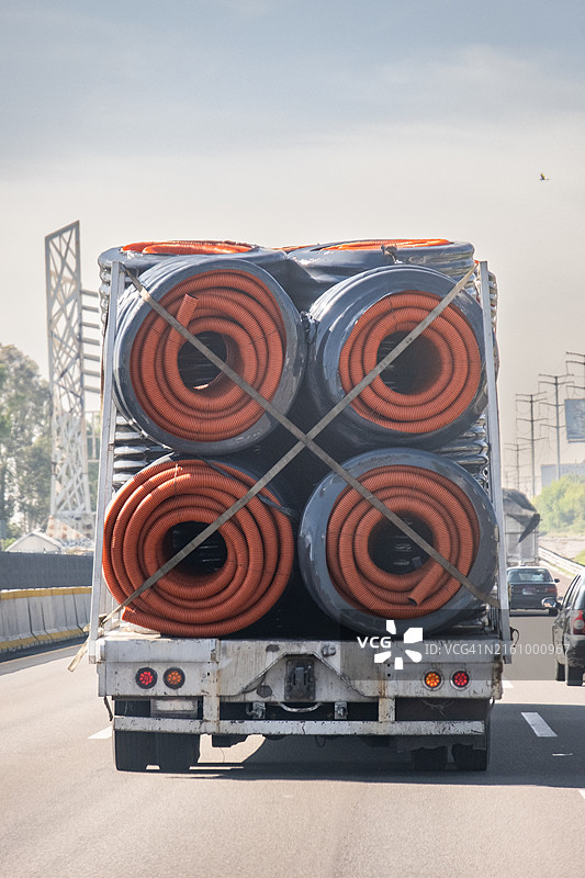 在高速公路上运输建筑用软管的卡车图片素材