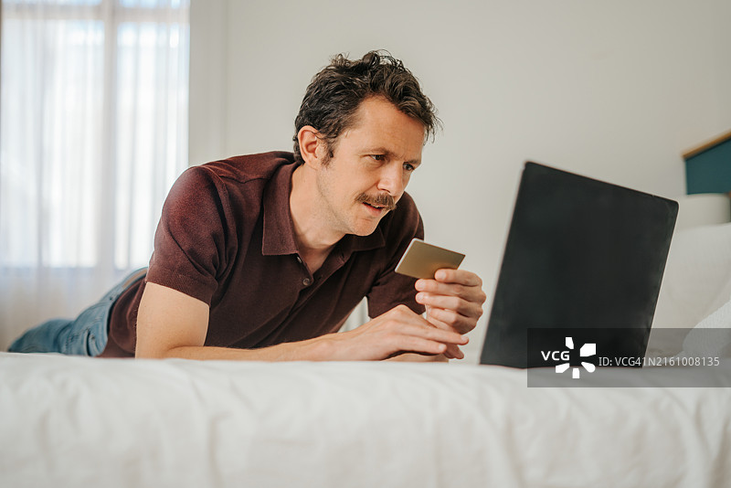 一名男子使用银行卡进行在线支付图片素材