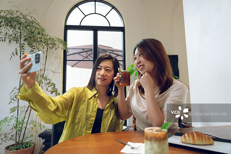 咖啡店里约会自拍的两位中国女性朋友图片素材