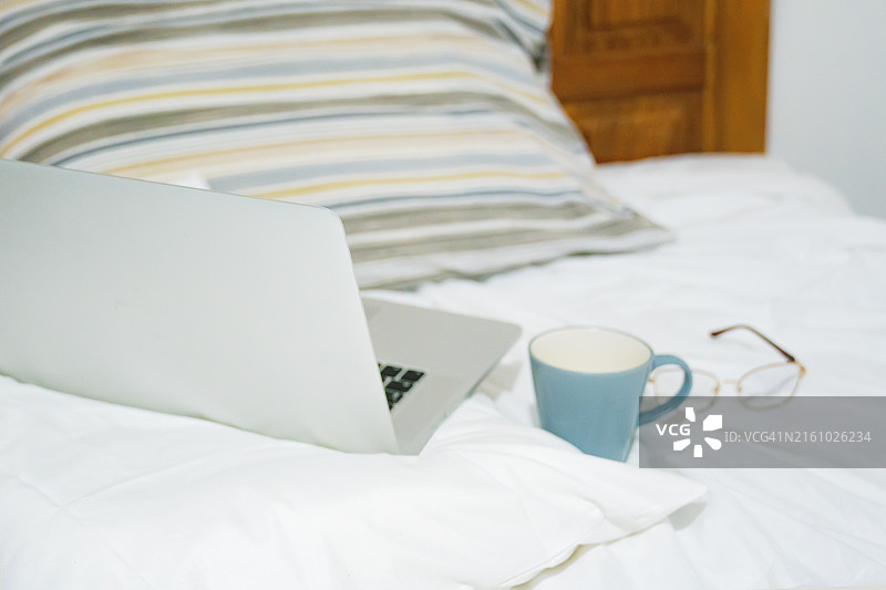 舒适的工作场景：未整理的床铺图片素材