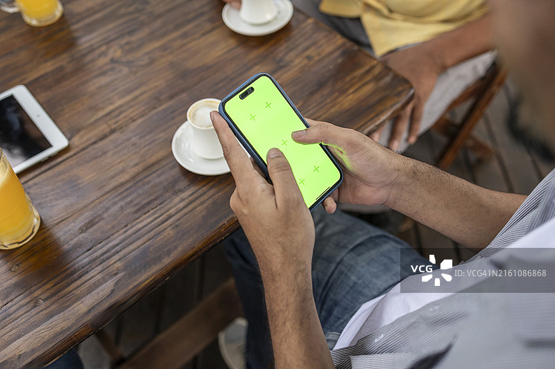 在咖啡店使用手机的黑人男人图片素材