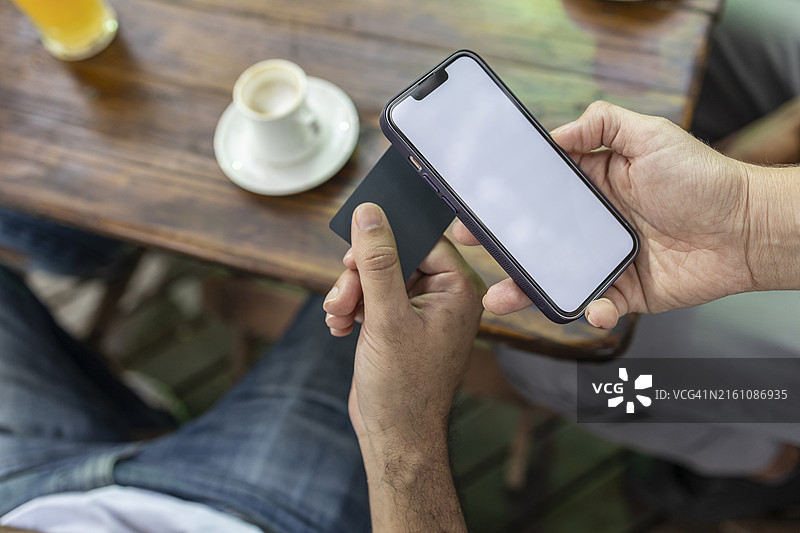 黑人男子在咖啡店用信用卡支付图片素材