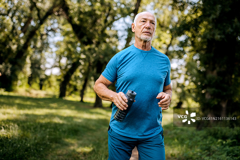 在森林中跑步的健壮老年男人图片素材