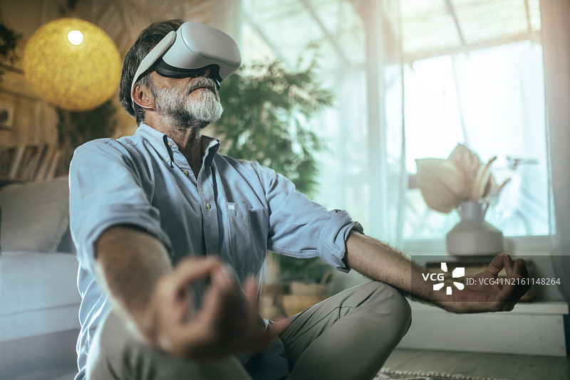冥想和瑜伽时使用VR头显的年长男人图片素材