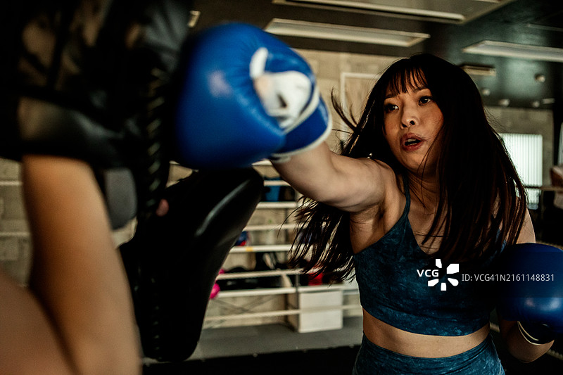 女性在拳击馆进行击打训练图片素材