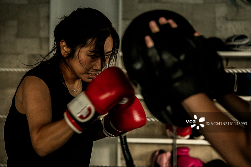 女性在拳击馆进行击打训练图片素材
