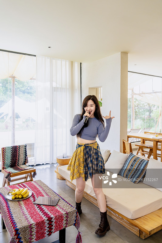 年轻女子在家中客厅唱歌图片素材