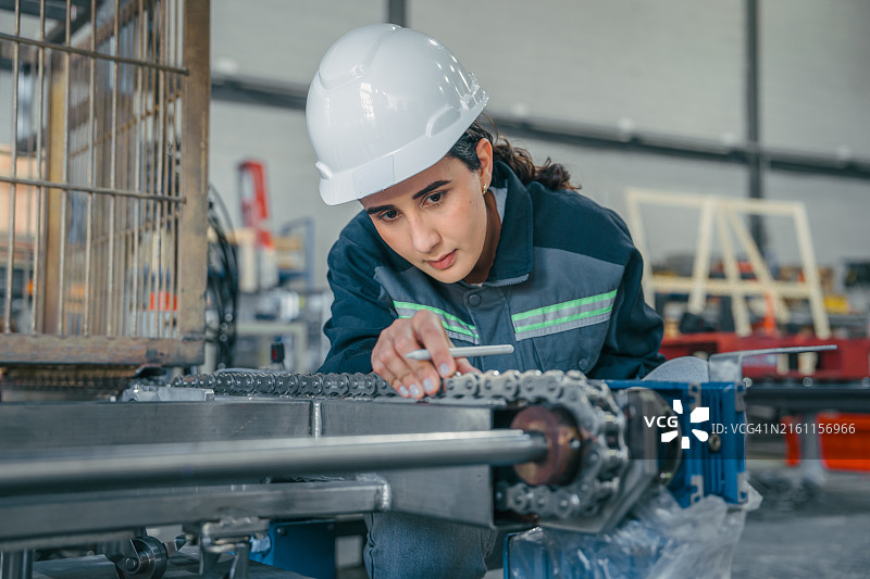 在工厂使用自动滚筒输送系统的女工程师图片素材
