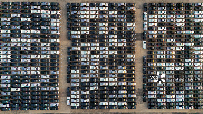 汽车工厂配送中心停放的新车航拍俯视图，商业汽车停车场在港口码头待售图片素材